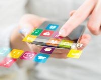 Apps auf Smartphone, die über den Display hinausgehen und eine Frau drauftippt