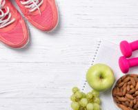 Sportschuhe, Obst, Nüsse und Hanteln liegen auf dem Boden
