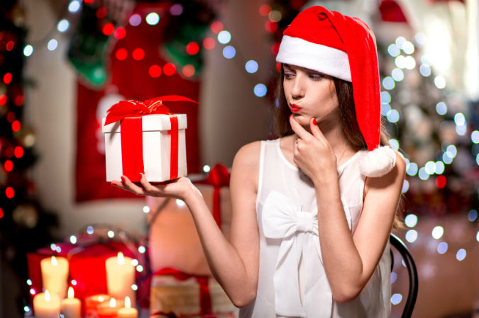 Frau mit Weihnachtsmütze und Geschenk