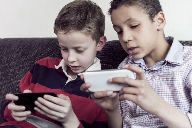 Kinder spielen mit Smartphone