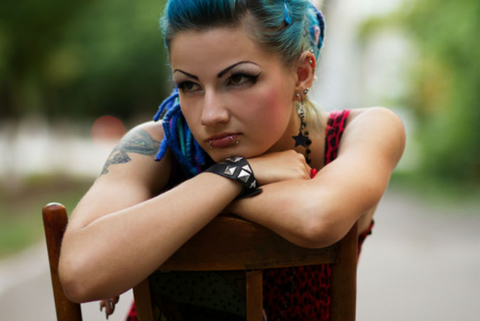 Eine Fraue mit Piercing und Tattoo.