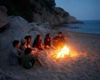 Menschen, die am Strand sitzen und singen