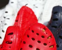 Die Spitzen von vielen Crocs in rot, schwarz und weiß