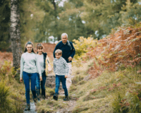 Großeltern gehen mit den Enkelkindern im Wald spazieren