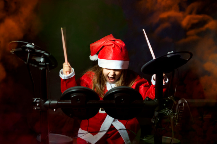 Mädchen mit Schlagzeug im Weihnachtsmannkostüm