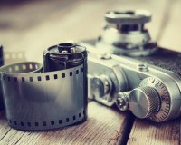 Kamera und Film liegen auf einer hölzernen Fläche