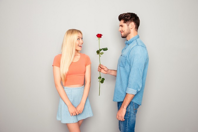 Junger Mann schenkt seiner Freundin eine Rose
